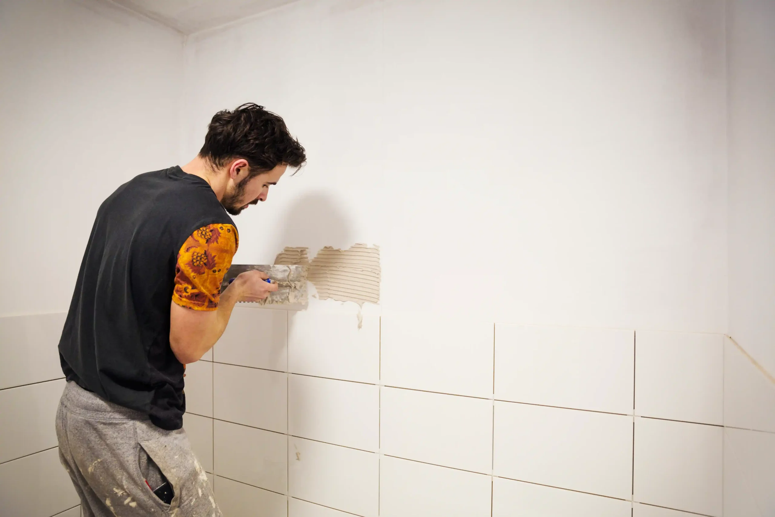 a-builder-tiler-placing-white-ceramic-tiles-on-a-2025-04-05-02-54-31-utc