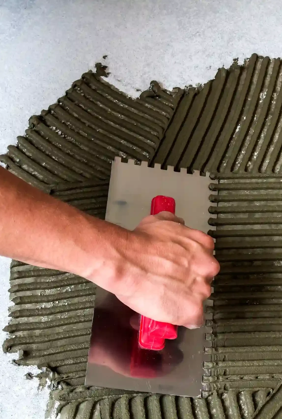 worker-hand-with-trowel-tool-for-tiles-installatio-2024-12-06-01-37-53-utc