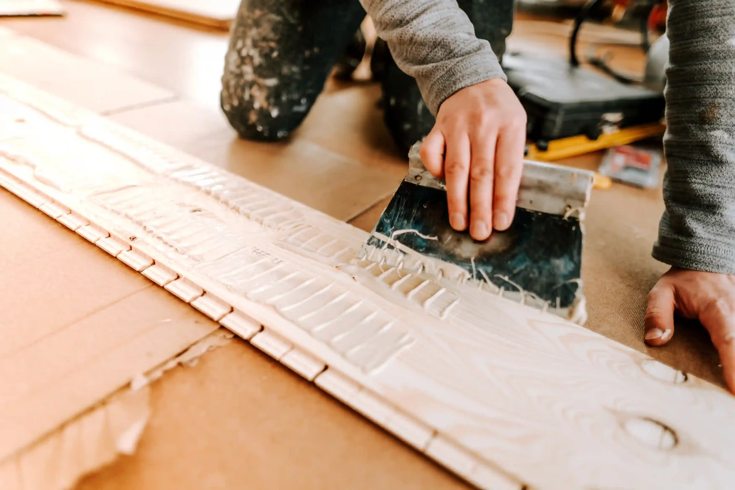 worker-laying-and-gluing-parquet-flooring-2024-09-12-07-24-55-utc